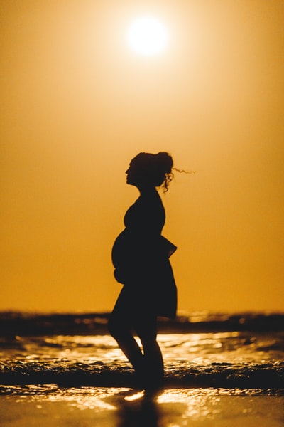 轮廓的女人站在在日落海滩
